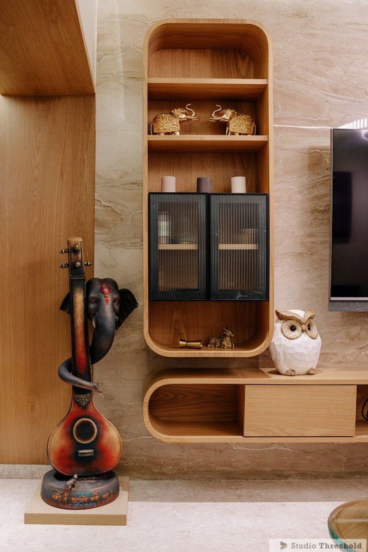 Curved TV unit with display shelf and Ganesha sculpture
